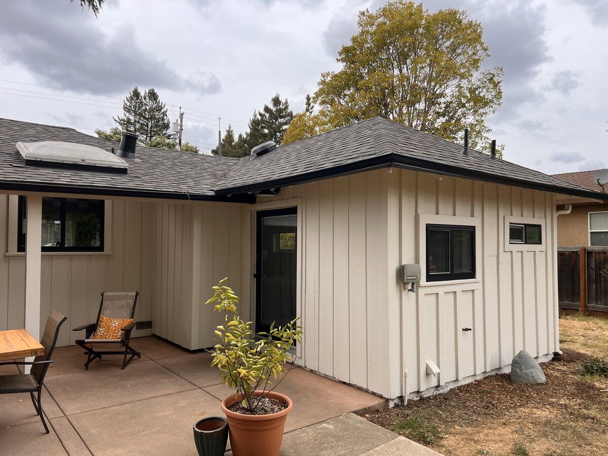 Freshly painted white board and batten cottage exterior