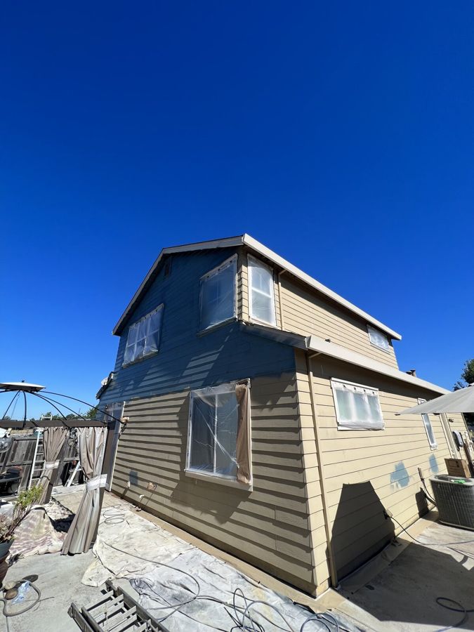 Two story home with fresh exterior paint under a blue sky