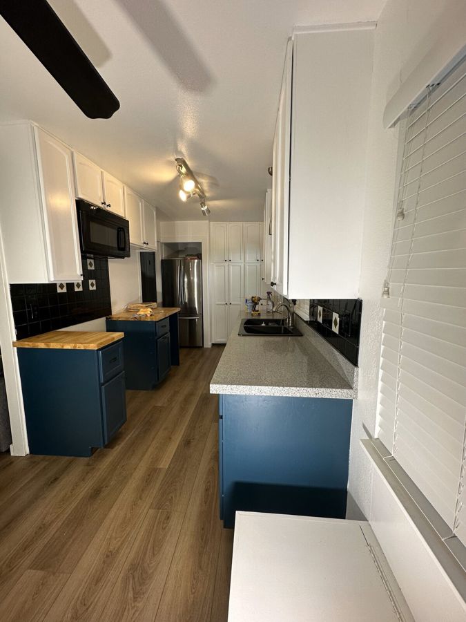 Kitchen with navy painted island cabinets and white uppers