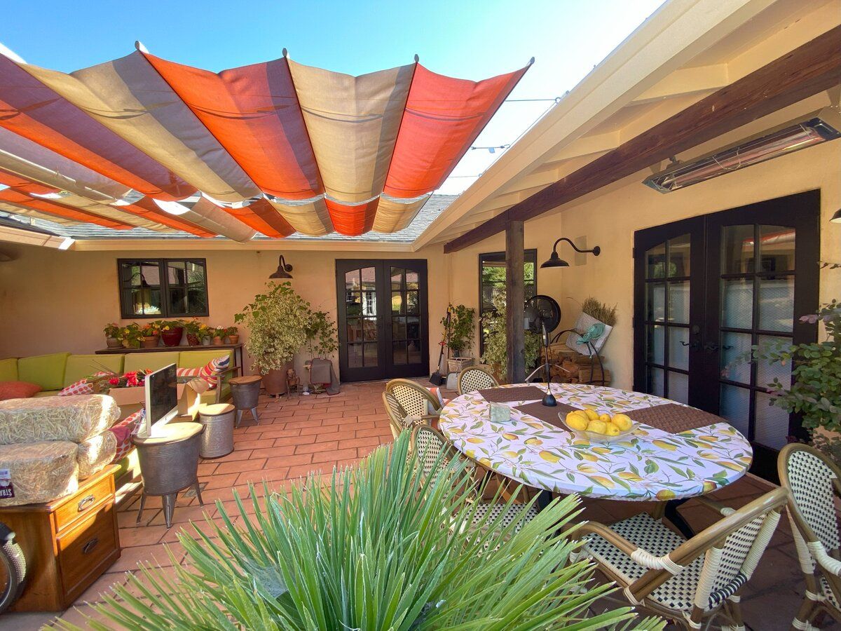 Covered patio with warm painted walls and colorful shade sails