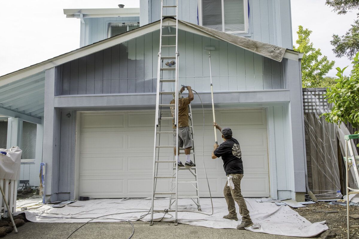 Palomares crew painting the exterior of a two story home from ladders